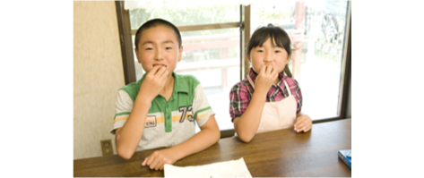 子供達がドーナツを食べている画像